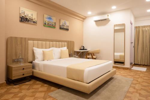 a bedroom with a large white bed and a mirror at HZ Bangalore Stories in Bengaluru