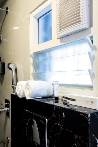 a bathroom with a sink and a window and towels at HZ Bangalore Stories in Bengaluru