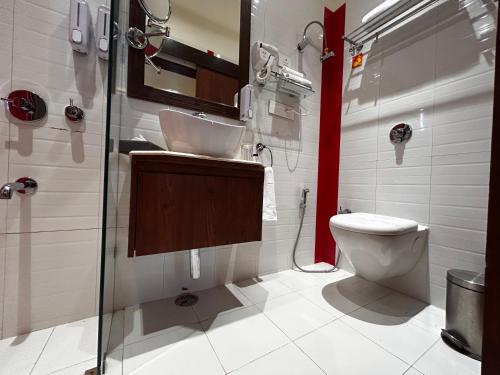 a bathroom with a toilet and a shower and a sink at Vaydantaa - Luxury Boutique Resort Mussoorie in Mussoorie