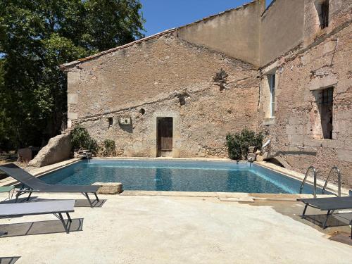 a swimming pool in front of a brick building at SCI Domaine Saint Martin le grand in Béziers