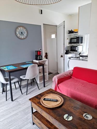 un salon avec un canapé rouge et une table dans l'établissement Adonis, à Paimpol