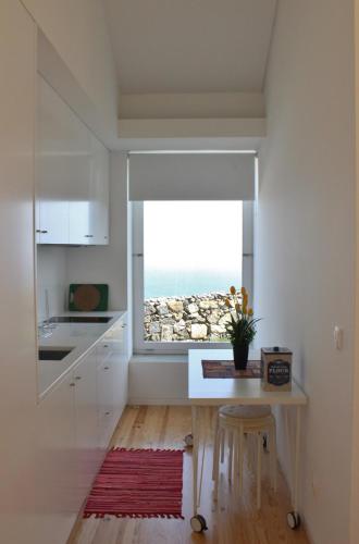 a kitchen with a table and a view of the ocean at Aldeia do Priolo in Nordeste