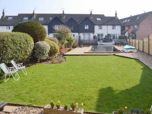 a yard with a lawn with a lawn at Heron's Quay in Wroxham
