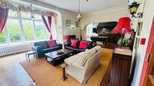 a living room with a couch and a piano at Berthlwyd Country House in Conwy
