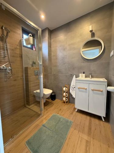 a bathroom with a shower and a sink and a toilet at Domki Białe Żagle in Władysławowo