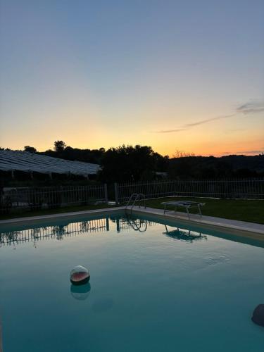 an empty swimming pool with a sunset in the background at L'Oro Verde in Moricone