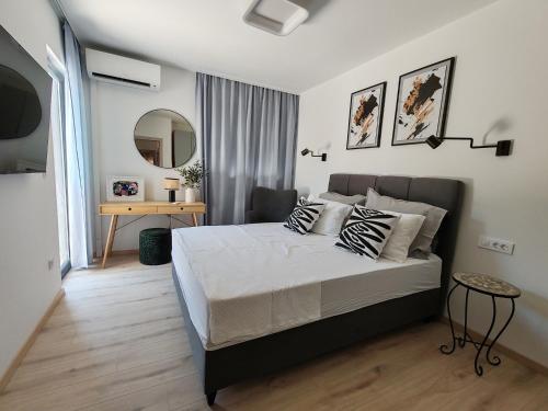 une chambre avec un grand lit et un miroir dans l'établissement MASLINA Rogoznica NEW VILA, à Rogoznica