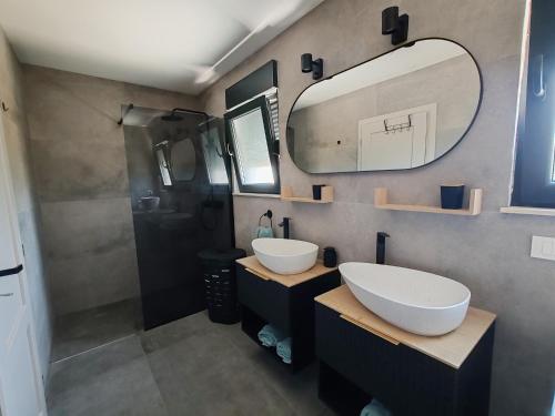 une salle de bain avec deux lavabos et un grand miroir dans l'établissement MASLINA Rogoznica NEW VILA, à Rogoznica