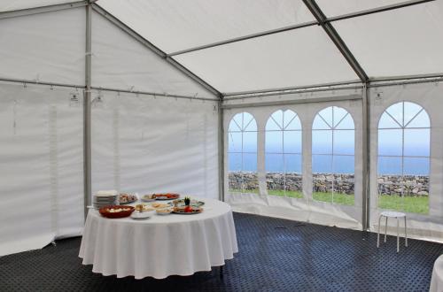 uma tenda branca com uma mesa com comida em Aldeia do Priolo em Nordeste