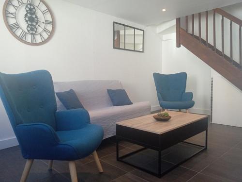 a living room with two blue chairs and a couch at Le duplex d'Abi in Saint-Étienne