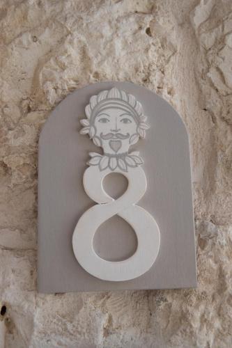 a sign with the number eight on a stone wall at La Pupa coi baffi - Edificio Storico in Centro in Conversano