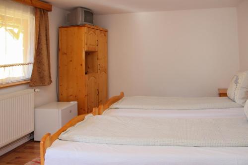 two twin beds in a room with a window at Pensiunea Patakparti in Praid