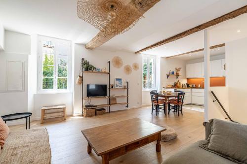 un salon avec une table et une cuisine dans l'établissement L'EMERAUDE duplex confortable au cœur de Cannes, proche plage du Midi et Palais, à Cannes