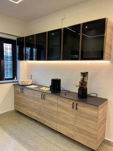 a kitchen with wooden cabinets and a counter top at Peaceful Private Residence in Hyderabad