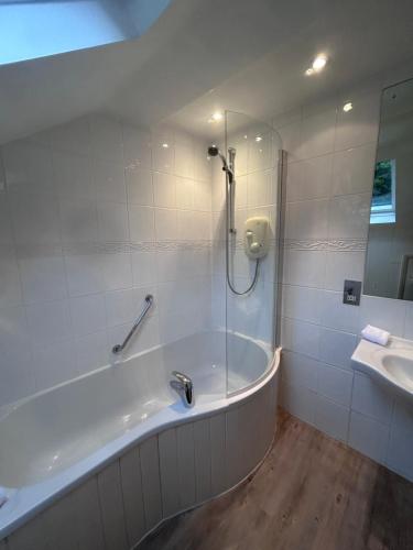 a bathroom with a bath tub and a sink at Lindeth Fell Country House in Bowness-on-Windermere