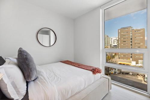 バンクーバーにあるModern 3BR Condo with Rooftop, Gym and Parking near Skytrainのベッドと大きな窓のある寝室