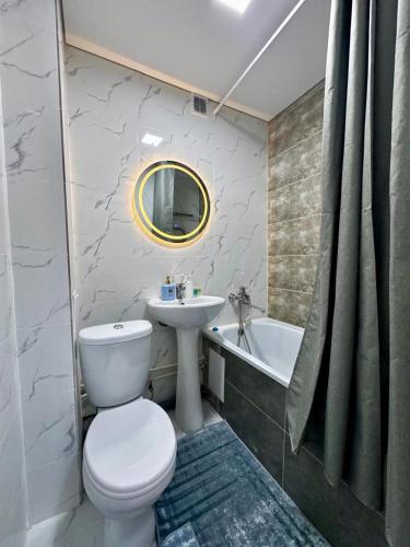 a bathroom with a toilet and a sink and a tub at Квартира - Терракота in Ustʼ-Kamenogorsk