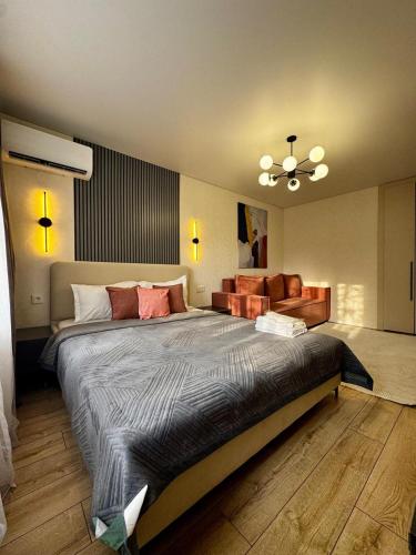 a bedroom with a large bed and a couch at Квартира - Терракота in Ustʼ-Kamenogorsk