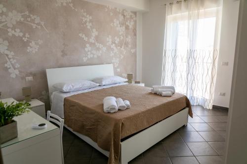 a bedroom with a bed with towels on it at Mare Blu in Giardini Naxos