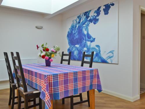 a table with a vase of flowers on it at Haulfryn Cottage in Menai Bridge