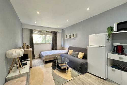 - un petit salon avec un canapé et un lit dans l'établissement Charming studio near the old port - Cannes, à Cannes