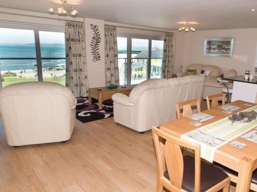 a living room with white furniture and a table and chairs at Apartment 11 - Latitude 51 in Westward Ho