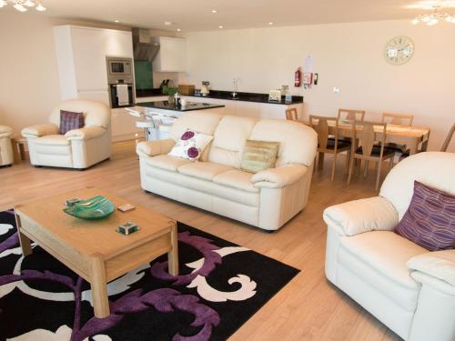 a living room with three couches and a table at Apartment 11 - Latitude 51 in Westward Ho
