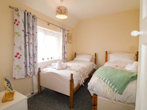two beds in a small room with a window at Oxcroft View in Worksop