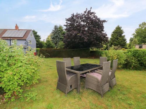 a table and chairs in the grass in a yard at Oxcroft View in Worksop