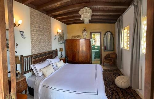 a bedroom with a large white bed and a couch at Riad DAR tya in Sale