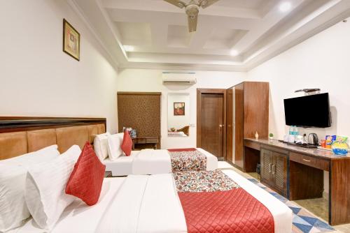 a hotel room with a bed and a flat screen tv at Airport La Sapphire Hotel & Restaurant in New Delhi