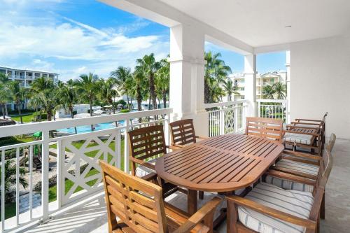 a balcony with a wooden table and chairs and the ocean at Alexandra Resort - All-Inclusive in Grace Bay