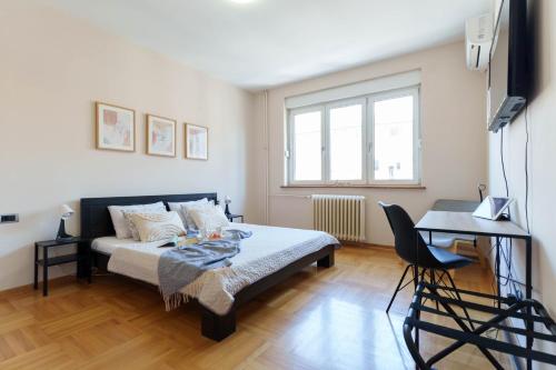 a bedroom with a bed and a table and a desk at Belgrade Central QUINCE Apartment in Belgrade