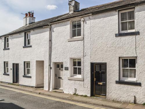 a white brick house on the side of a street at Pollywiggle Cottage in Keswick