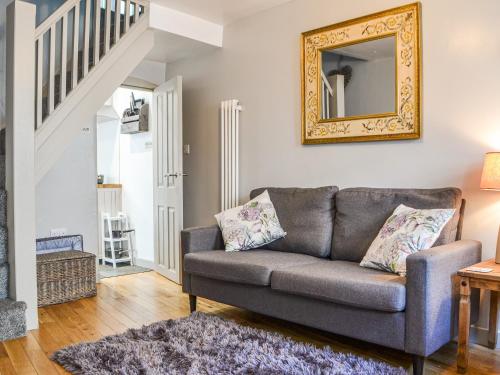 a living room with a couch and a mirror at Pollywiggle Cottage in Keswick