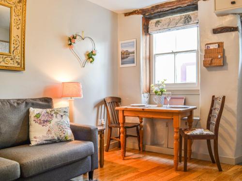 a living room with a couch and a table at Pollywiggle Cottage in Keswick