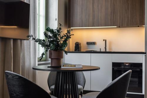 a table with a vase of flowers on it in a kitchen at Luxury Design Loft Escape In Riga in Rīga