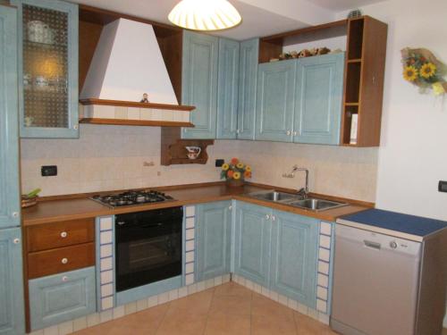 una cocina con armarios azules y fregadero en Debora en Roncegno