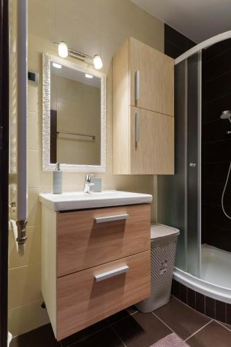 a bathroom with a sink and a mirror and a tub at Belgrade Central QUINCE Apartment in Belgrade