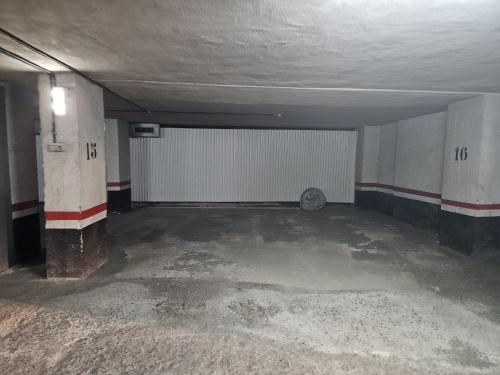 an empty parking garage with a white garage door at Apartamento céntrico con vistas a la Ría! garaje, ideal 2-4 in Bilbao