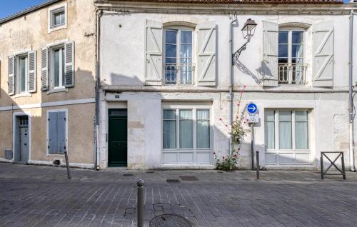 ein weißes Gebäude mit Fenstern und einer Straße in der Unterkunft Appartement Proche Plage in La Rochelle