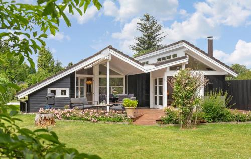 a small black house with a deck and lawn at Lovely Home In Dronningmølle With Wifi in Dronningmølle