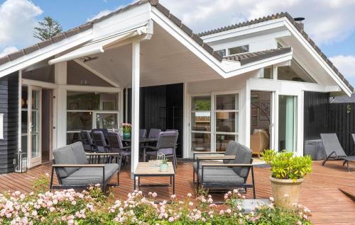 a patio with chairs and tables on a deck at Lovely Home In Dronningmølle With Wifi in Dronningmølle