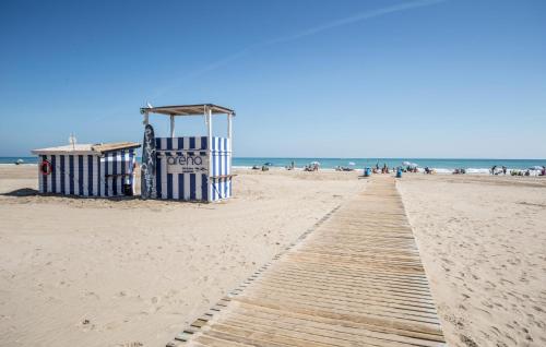 a boardwalk on a beach with people in the ocean at Beautiful Apartment In Canet De Berenguer in Canet de Berenguer
