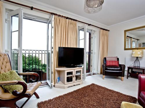 a living room with a flat screen tv on a table at Cormorant View in Weymouth
