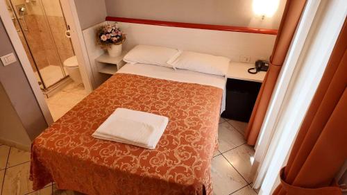 a small bedroom with a bed and a bathroom at Hotel Brianza in Milan