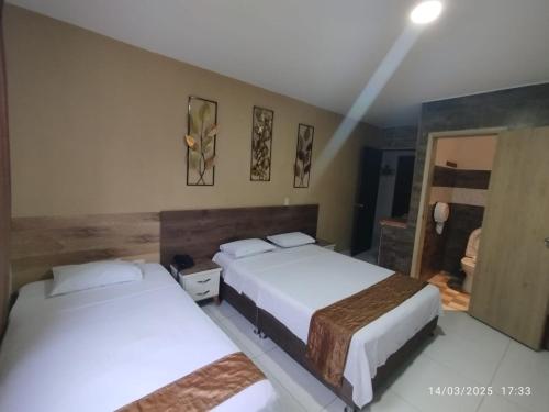 two beds in a hotel room with two beds at San Francisco Plaza Real in Bucaramanga