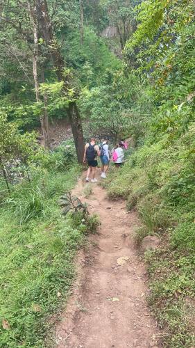 a group of people walking down a dirt trail at Local Villa Lodge in Arusha