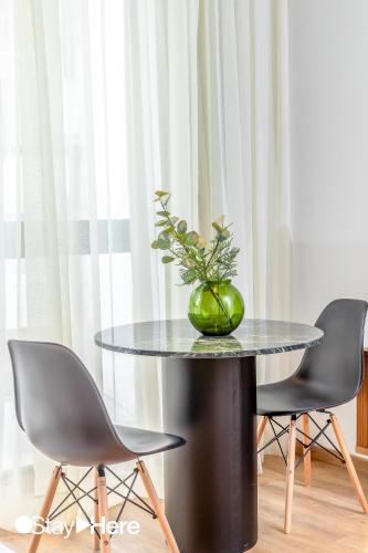 a black table with a plant on it with two chairs at Stayhere Casablanca - Gauthier 1 - Modern Residence in Casablanca