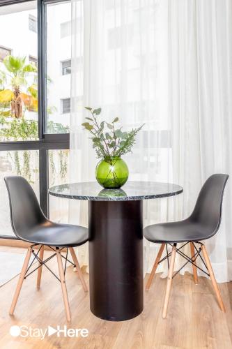 a black table with a green vase on top of it at Stayhere Casablanca - Gauthier 1 - Modern Residence in Casablanca